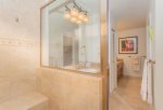 Enjoy twin vanities with granite counter tops, tile flooring, tropical wallpaper, a shower and large over-sized soaking tub